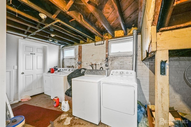 washroom with washing machine and dryer and a healthy amount of sunlight