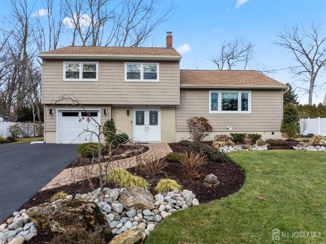 view of front of house featuring a garage, french doors, and a front lawn