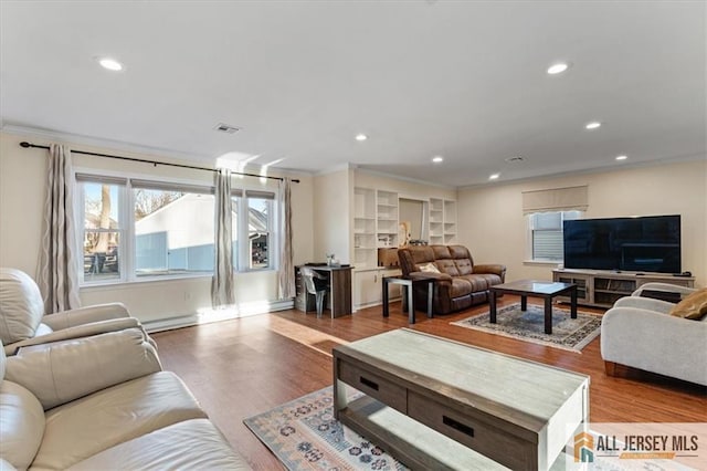 living area featuring crown molding, visible vents, and wood finished floors