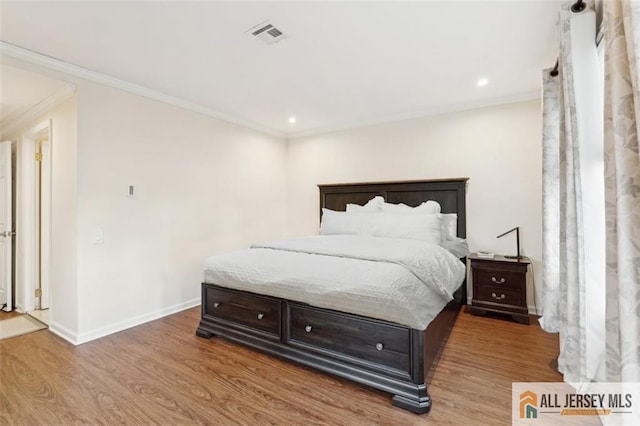 bedroom with ornamental molding, recessed lighting, baseboards, and wood finished floors