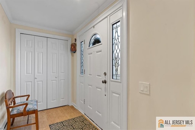 foyer featuring light wood-style floors, plenty of natural light, and ornamental molding