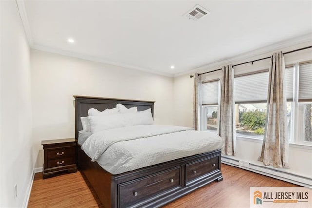 bedroom featuring crown molding, light wood finished floors, a baseboard radiator, visible vents, and baseboards