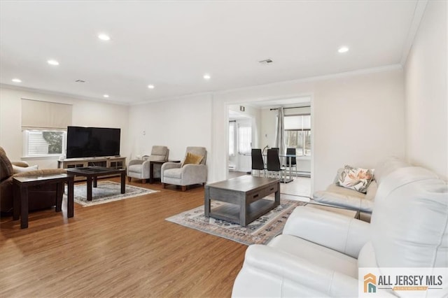 living room with light wood-style floors, recessed lighting, visible vents, and crown molding