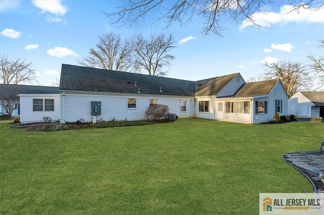 rear view of property with a yard and cooling unit