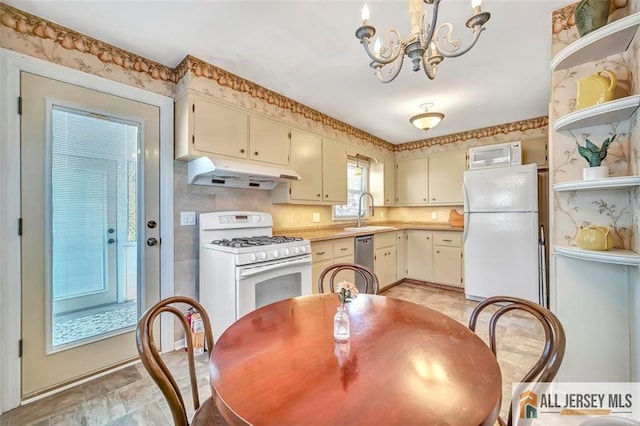 kitchen featuring open shelves, a sink, a notable chandelier, under cabinet range hood, and white appliances