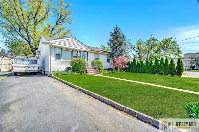 view of front of home with driveway and a front lawn