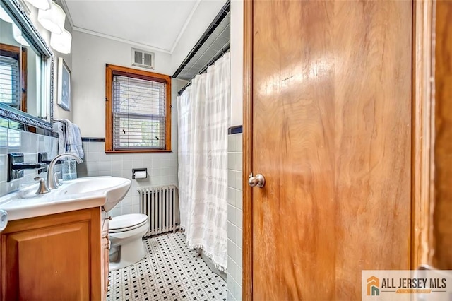 bathroom featuring radiator heating unit, tile walls, toilet, and a healthy amount of sunlight