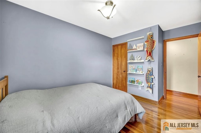 bedroom featuring baseboards and wood finished floors