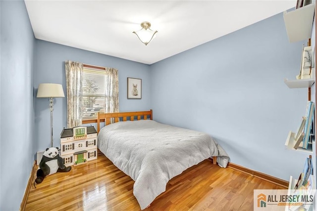 bedroom featuring baseboards and wood finished floors
