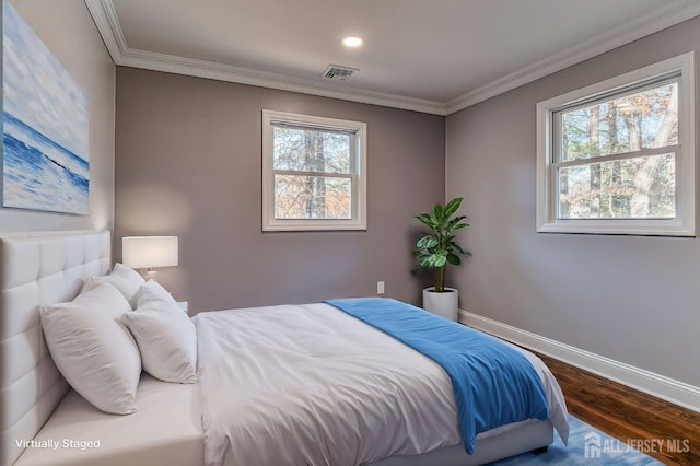 bedroom with hardwood / wood-style flooring, crown molding, and multiple windows