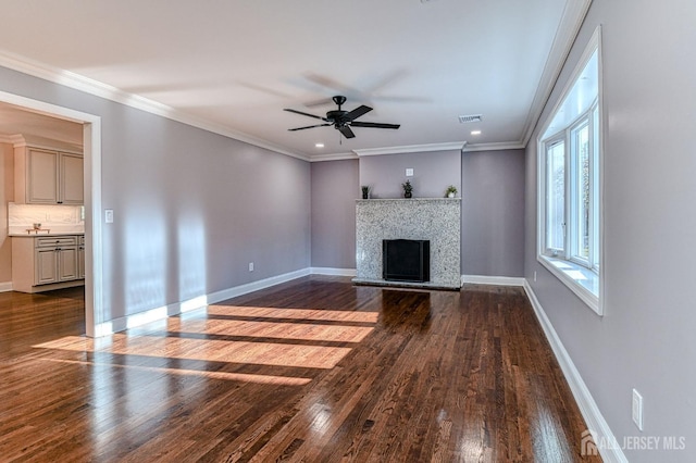 unfurnished living room featuring dark hardwood / wood-style floors, ceiling fan, and crown molding