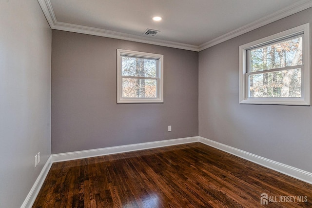 spare room with ornamental molding, a wealth of natural light, and dark wood-type flooring