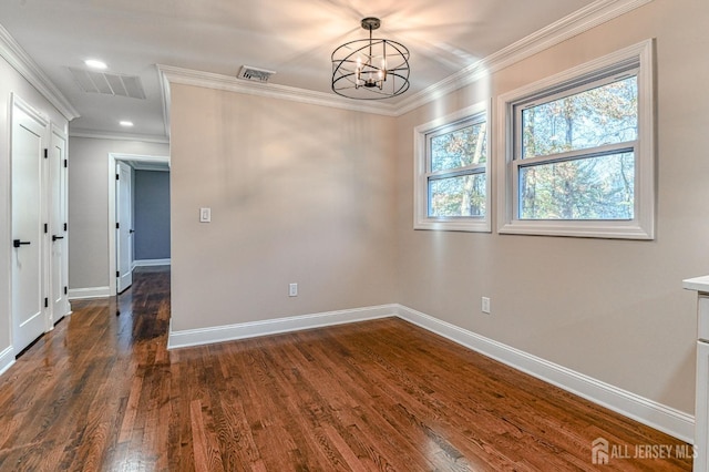 empty room featuring crown molding, dark wood-type flooring, and a notable chandelier