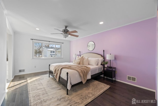 bedroom featuring crown molding, dark wood-type flooring, and ceiling fan