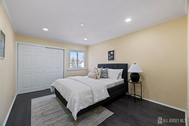 bedroom featuring ornamental molding, dark wood-type flooring, and a closet