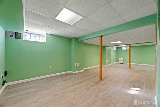 basement featuring wood-type flooring and a paneled ceiling