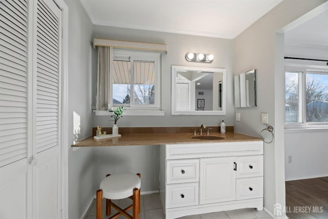 bathroom with crown molding, tile patterned floors, and vanity