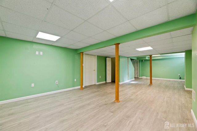 basement featuring light hardwood / wood-style flooring and a paneled ceiling