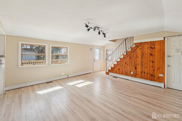 114 Pine Island Ter, Old Bridge, NJ 07735 - unfurnished living room with a baseboard radiator, wood finished floors, stairs, track lighting, and baseboards