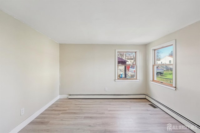 114 Pine Island Ter, Old Bridge, NJ 07735 - spare room featuring baseboard heating, wood finished floors, and baseboards