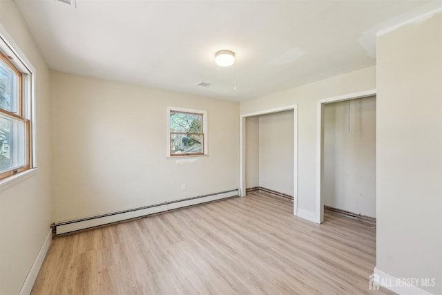 114 Pine Island Ter, Old Bridge, NJ 07735 - unfurnished bedroom featuring a baseboard heating unit, light wood-type flooring, two closets, and baseboards