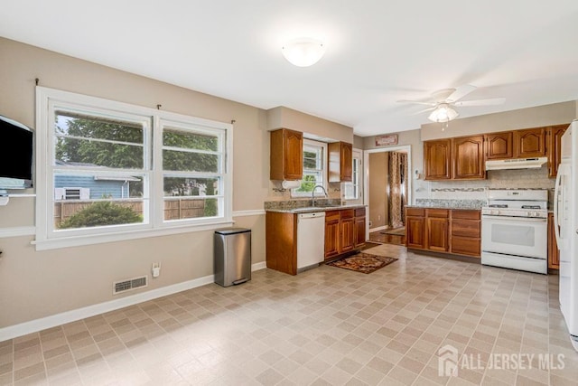 1010 Dorn Ave, Middlesex, NJ 08846 - kitchen featuring white appliances, brown cabinets, under cabinet range hood, decorative backsplash, and a sink