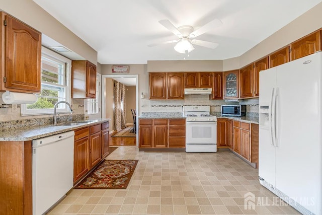 1010 Dorn Ave, Middlesex, NJ 08846 - kitchen featuring white appliances, brown cabinets, under cabinet range hood, and backsplash