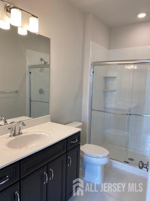full bath with tile patterned flooring, a stall shower, toilet, vanity, and recessed lighting