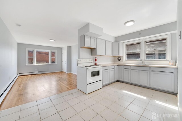 kitchen featuring baseboard heating, sink, light tile patterned floors, and white electric range