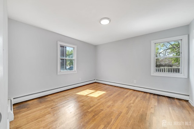 spare room with plenty of natural light, light hardwood / wood-style floors, and baseboard heating