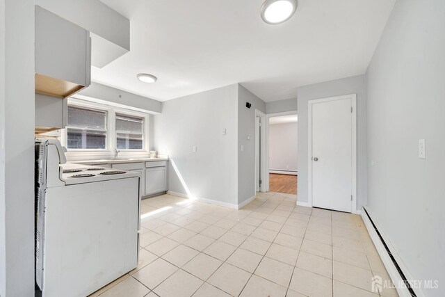 kitchen featuring sink, light tile patterned flooring, stove, and baseboard heating