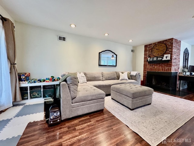 living room with recessed lighting, a fireplace, visible vents, and dark wood-style flooring