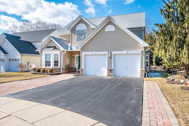 view of front of home with stone siding, driveway, and a garage