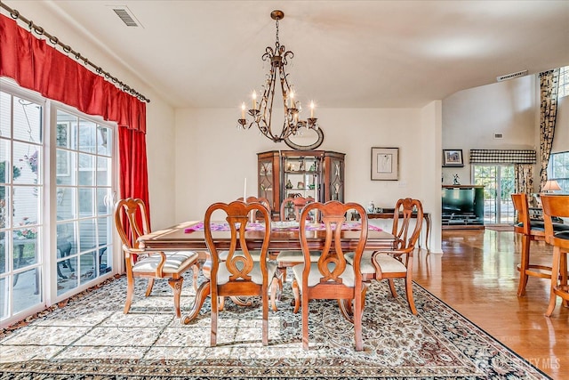 dining space with a notable chandelier, wood finished floors, and visible vents