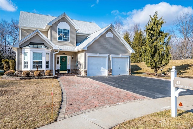 view of front of property featuring aphalt driveway, a garage, and a shingled roof