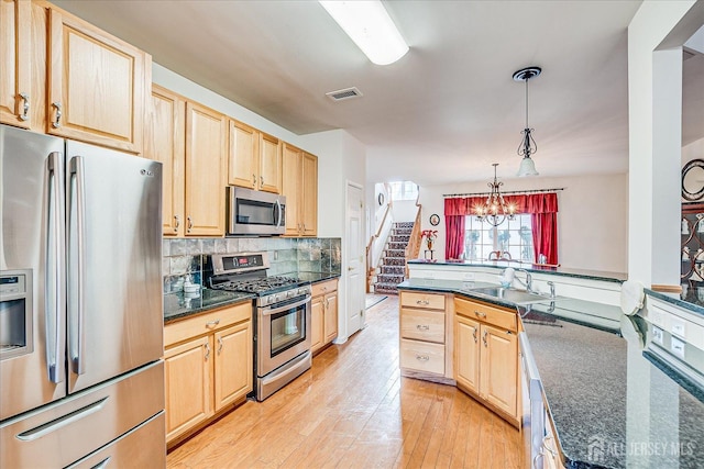 kitchen featuring light brown cabinetry, visible vents, appliances with stainless steel finishes, and a sink