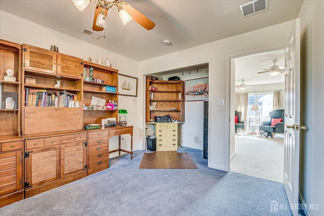 carpeted office with visible vents, baseboards, and a ceiling fan