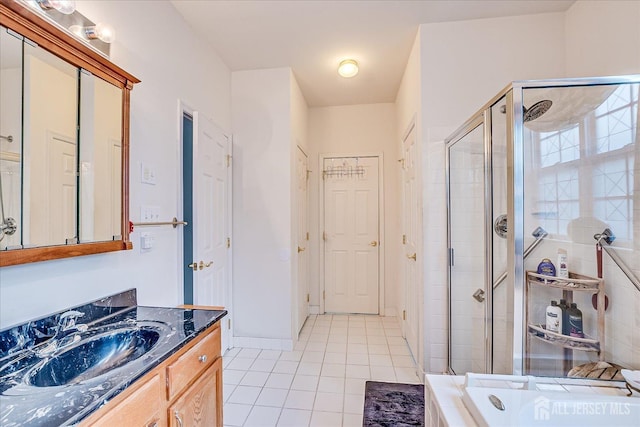 bathroom featuring vanity, baseboards, tile patterned flooring, a shower stall, and a bath