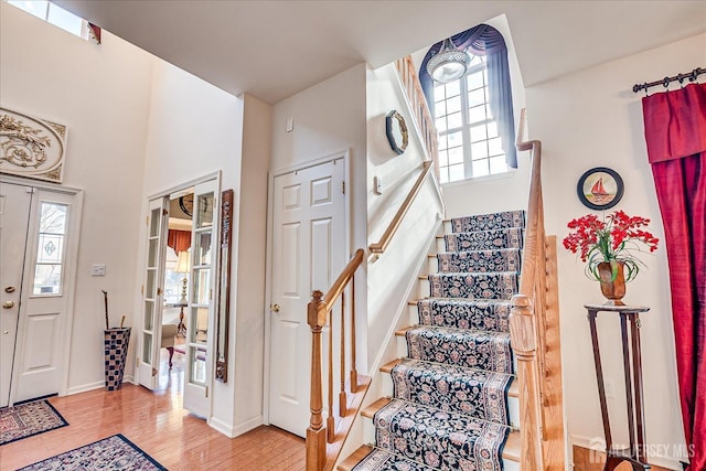 entryway featuring stairway, wood finished floors, and baseboards