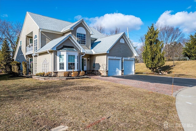 view of front facade with an attached garage, a shingled roof, a front lawn, stone siding, and aphalt driveway