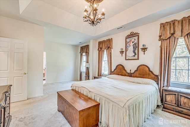 bedroom with visible vents, baseboards, light colored carpet, an inviting chandelier, and a raised ceiling