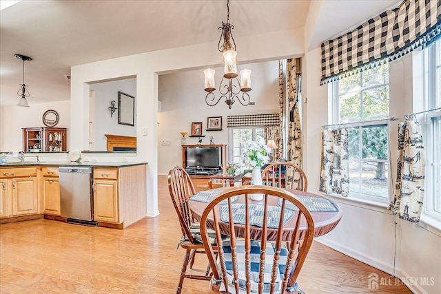 dining room with light wood-type flooring and a chandelier