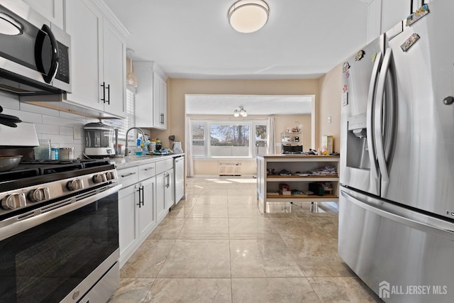 kitchen with light countertops, light tile patterned floors, decorative backsplash, appliances with stainless steel finishes, and white cabinetry