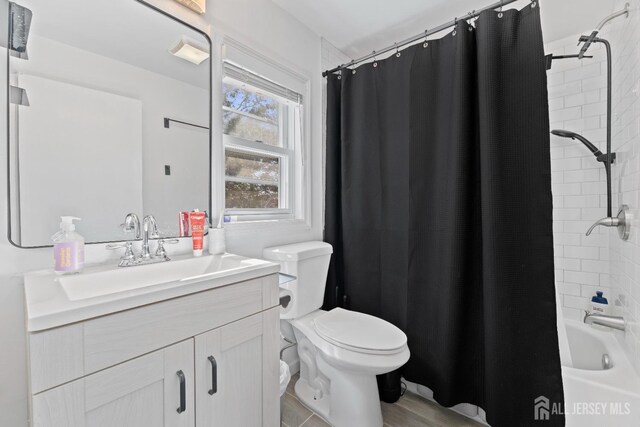 full bathroom featuring toilet, vanity, and shower / tub combo with curtain