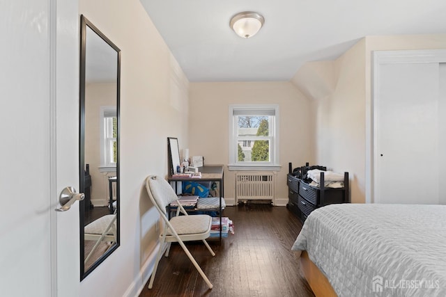 bedroom with radiator, baseboards, and hardwood / wood-style floors