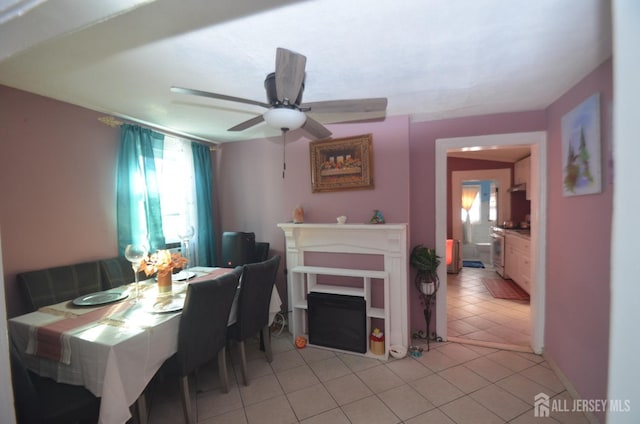dining space with a ceiling fan and light tile patterned flooring