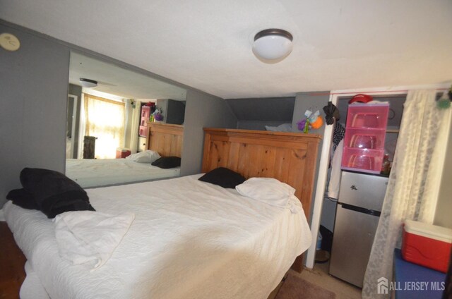 bedroom featuring stainless steel refrigerator