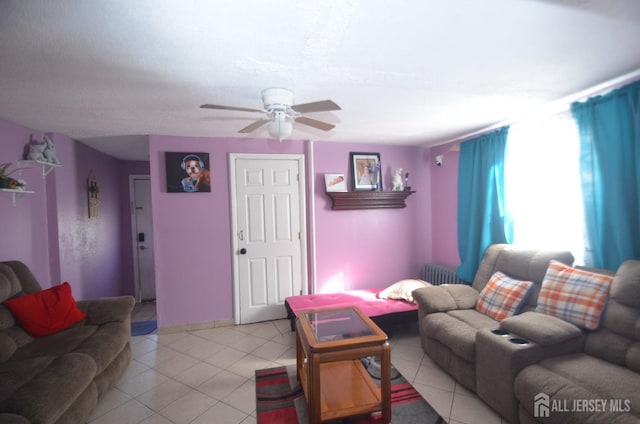 tiled living room with radiator and ceiling fan