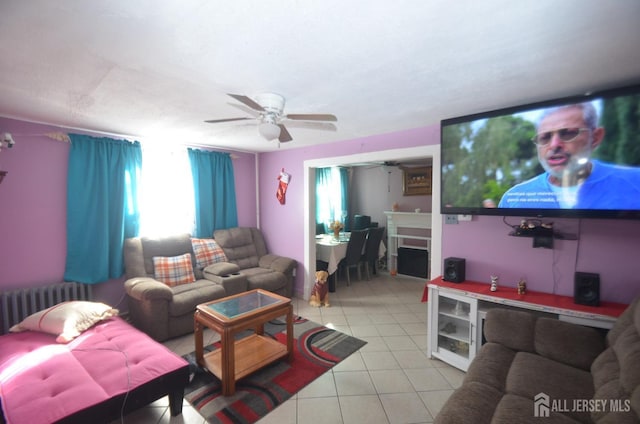 living area featuring radiator heating unit, light tile patterned floors, and ceiling fan
