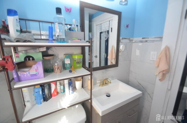 bathroom with vanity and tile walls